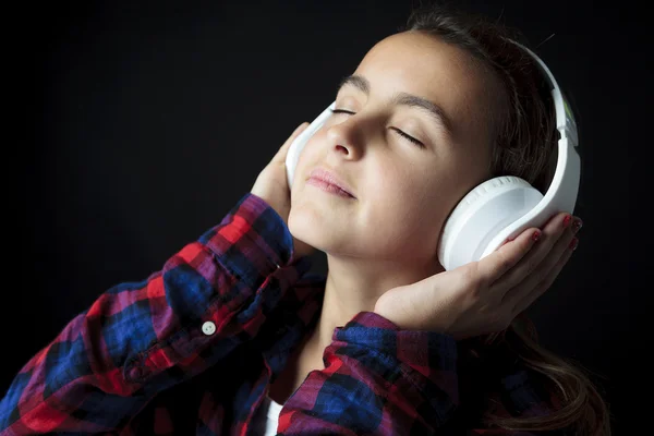 Meisje luisteren muziek met een Mp3-speler, geïsoleerd op zwart — Stockfoto