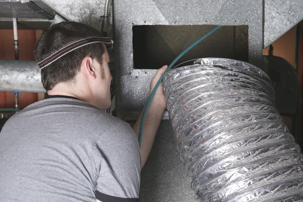 Un nettoyeur de ventilation au travail avec outil Photo De Stock