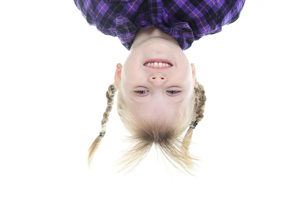 Legrační malá holčička visí vzhůru nohama na bílém pozadí — Stock fotografie