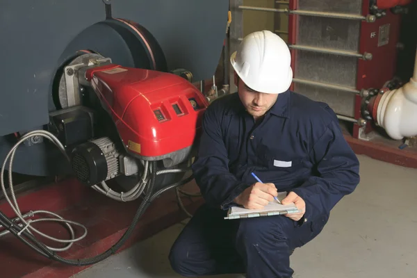 Maintenance engineer checking technical data of heating system e — Stock Photo, Image