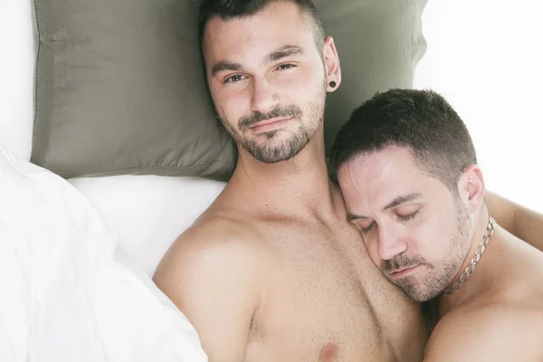 A homosexual couple onder a bed in studio white — Stock Photo, Image