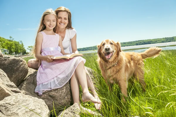 Kleines Mädchen mit Mutter liest im Sommerpark ein Buch — Stockfoto