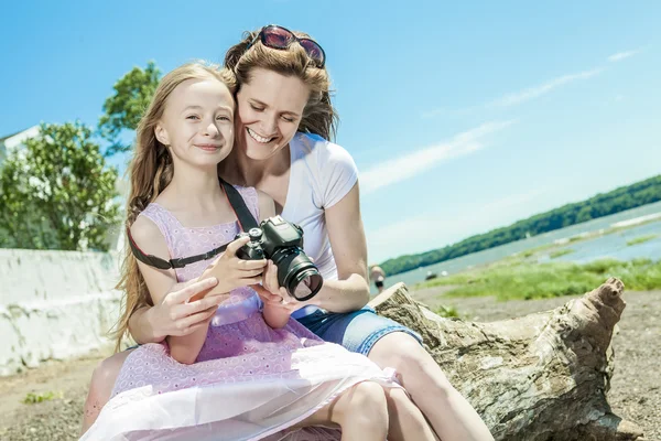 Fröhliche Mutter beim Fotografieren ihrer süßen kleinen Tochter. — Stockfoto