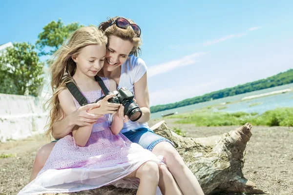Cheerful mother taking picture of her cute little daughter. — Stock Photo, Image