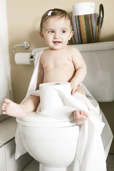 Criança rasgando papel higiênico no banheiro — Fotografia de Stock