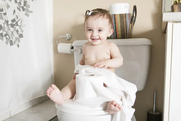 Toddler ripping up toilet paper in bathroom — Stock Photo, Image