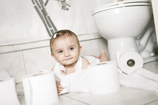 Toddler ripping up toilet paper in bathroom — Stock Photo, Image