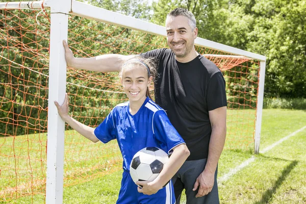 Adolescente ragazza con suo padre giocare a calcio in una bella giornata — Foto Stock