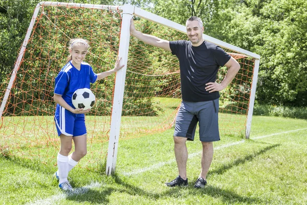 Teenager girl with father play soccer — Stockfoto