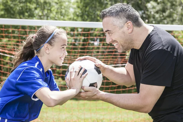 Adolescente com seu pai jogar futebol em um belo dia — Fotografia de Stock