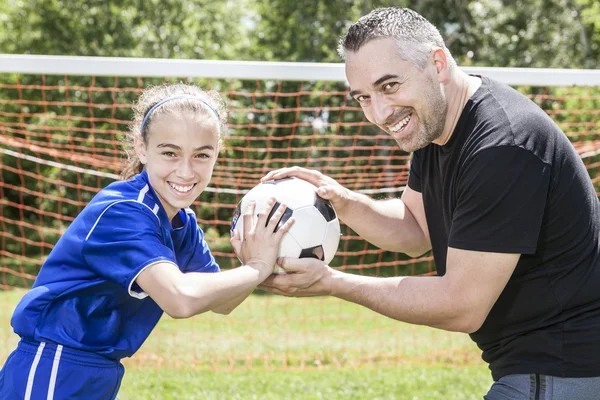 Adolescente ragazza con suo padre giocare a calcio in una bella giornata — Foto Stock