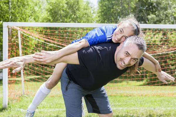 Adolescente con su padre jugar al fútbol en un hermoso día — Foto de Stock