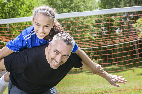 Adolescente ragazza con suo padre giocare a calcio in una bella giornata — Foto Stock