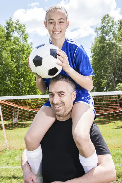 Adolescente con su padre jugar al fútbol en un hermoso día — Foto de Stock