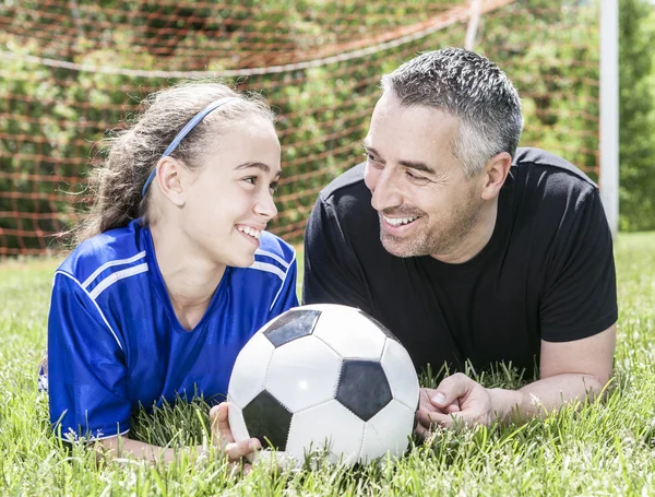 Adolescente ragazza con suo padre giocare a calcio in una bella giornata — Foto Stock