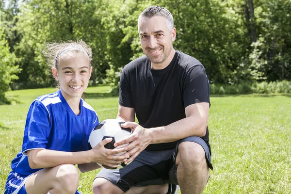 Tonåring flicka med sin far spela fotboll i en vacker dag — Stockfoto