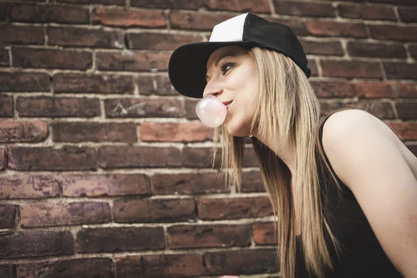 Beautiful modern girl near the brickwall. — Stock Photo, Image