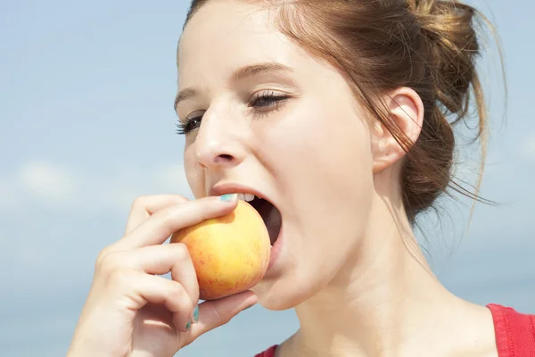 Lány eszik őszibarack — Stock Fotó