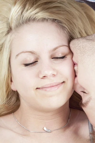 Glada unga älskande par embracing, vit bakgrund — Stockfoto