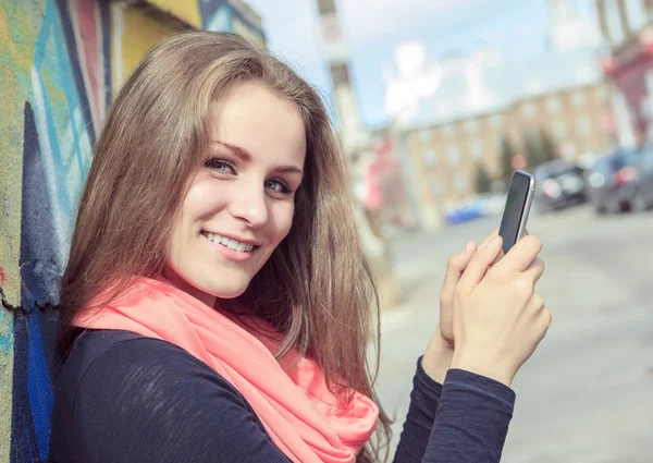 Young and beautiful girl posing against graffiti wall — Stock Photo, Image