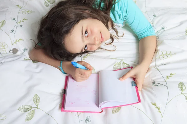 Menina escrevendo diário na cama — Fotografia de Stock