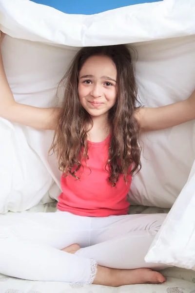 Νεαρή κοπέλα ξαπλωμένη στο κρεβάτι κάτω από τα σκεπάσματα — Φωτογραφία Αρχείου
