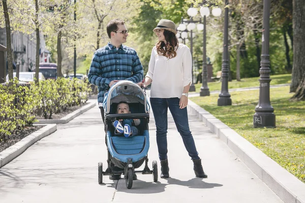 Familia joven con cochecitos de bebé en paseo por la ciudad — Foto de Stock