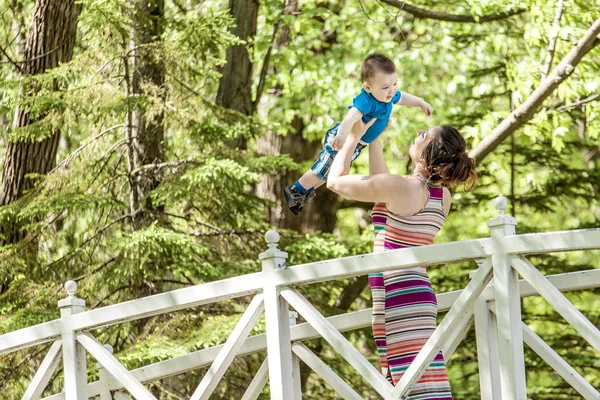 Schöne Mutter und kleiner Junge im Wald — Stockfoto