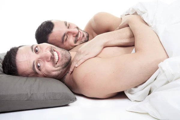 A homosexual couple onder a bed in studio white — Stock Photo, Image