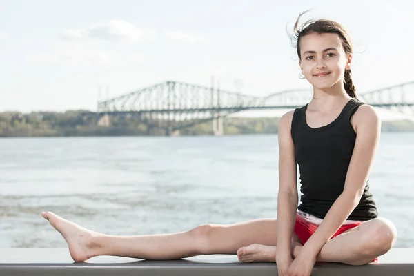 Happy little girl meditates with bridge on the back. — ストック写真