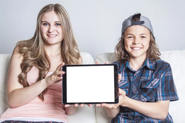 Frère et fille utilisant une tablette numérique sur le canapé à la maison — Photo