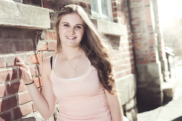 Young elegant woman in front of brick wall backround — Stock Photo, Image