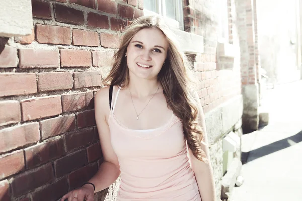 Young elegant woman in front of brick wall backround — Stock Photo, Image