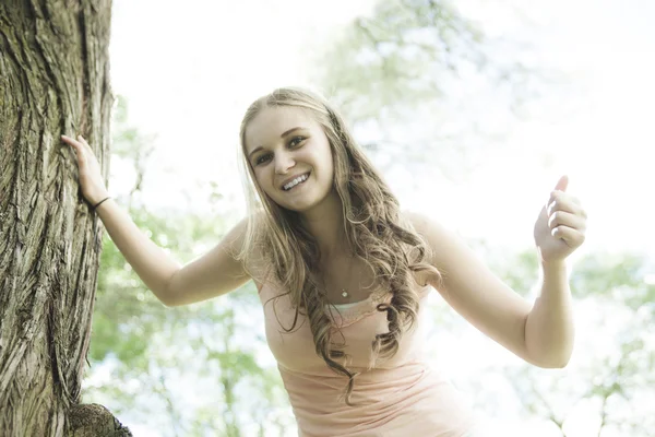 Beautiful smiling girl standing over green summer background — Stok fotoğraf
