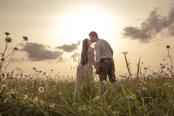 Молода пара закохана на відкритому повітрі на заході сонця — стокове фото