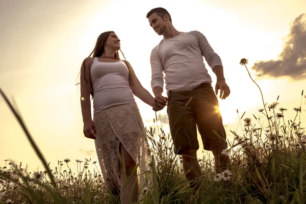 Mladý pár v lásce venkovní v západu slunce — Stock fotografie