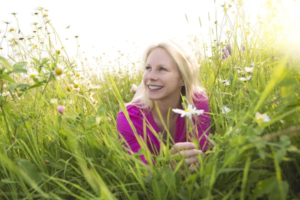 Beautiful woman enjoying daisy in a field — Stock Photo, Image