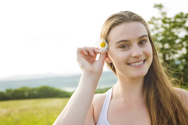 Beautiful woman enjoying daisy in a field — Stock Photo, Image