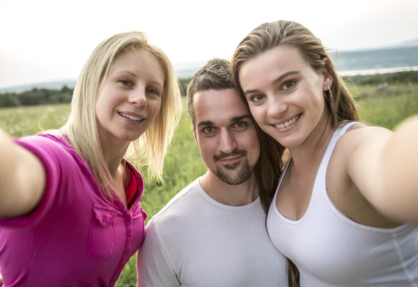 Happy friends spending free time together in a field — Stock Photo, Image