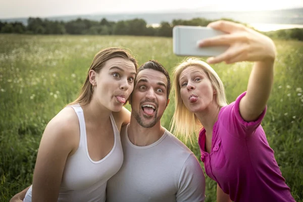 Happy friends spending free time together in a field — Stock Photo, Image