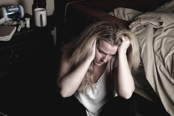 En kvinne på soverommet føler seg deprimert. . – stockfoto