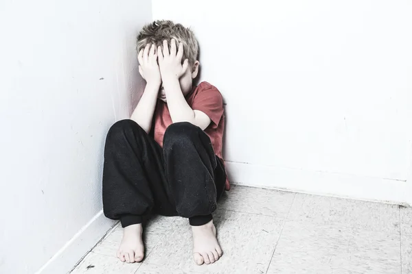 Negligenciada criança solitária encostada à parede — Fotografia de Stock