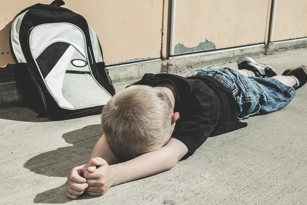 Ein sehr trauriger Junge auf dem Schulhof — Stockfoto