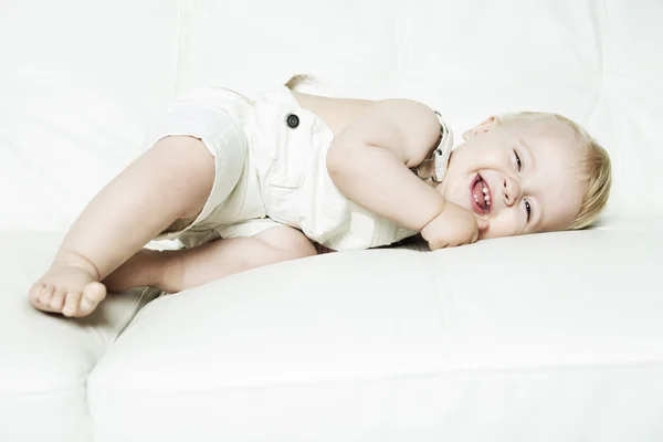 Niño de un año aprende en un sofá —  Fotos de Stock