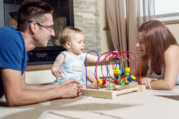 Pais bebê sentado no chão jogar com brinquedo — Fotografia de Stock