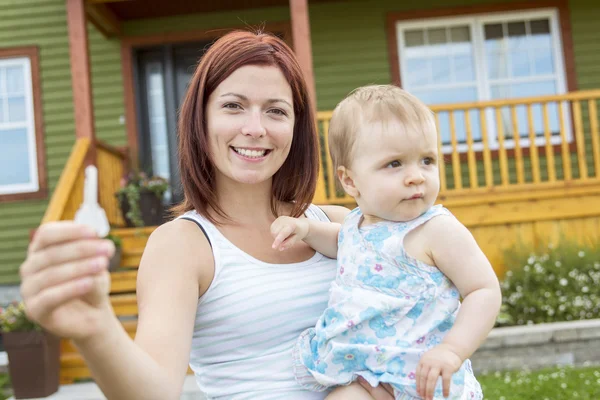 Mother and baby in front of the house — Stock Photo, Image