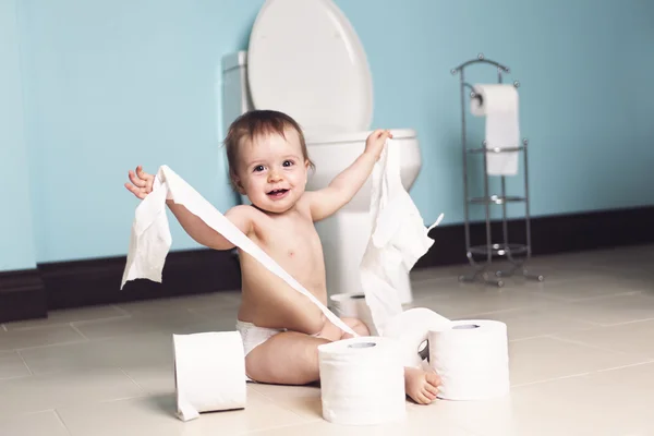 Småbarn riva upp toalettpapper i badrummet — Stockfoto