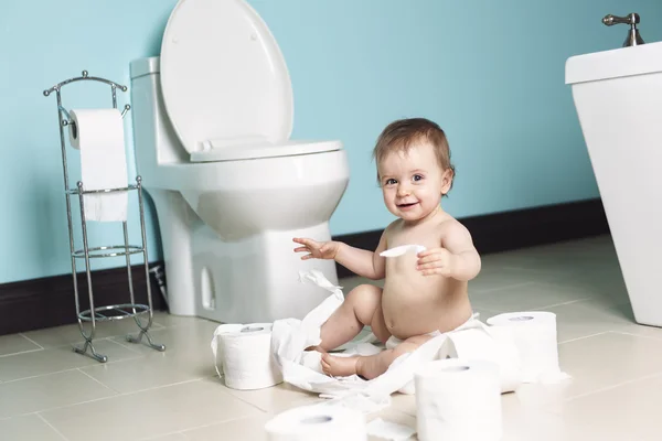 Νήπιο σκίζοντας χαρτί τουαλέτας στο μπάνιο — Φωτογραφία Αρχείου