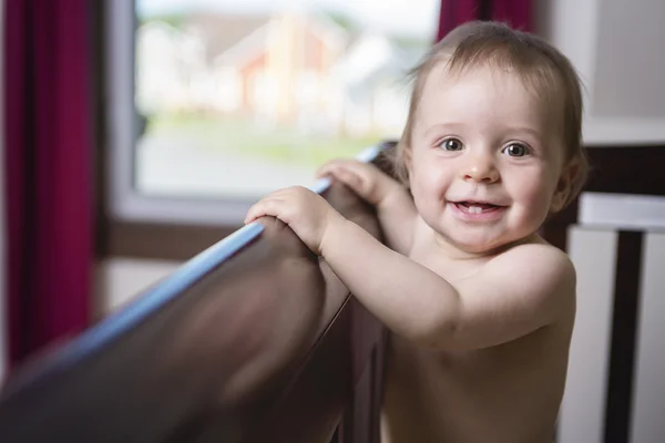 Beautiful baby in a crib at home — Stock Photo, Image