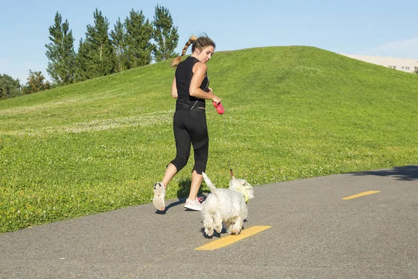 Vacker ung kvinna jogging med sin hund — Stockfoto